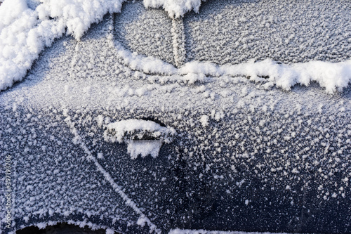 frozen car. the side of the car, doors and handles covered with snow and frost. photo