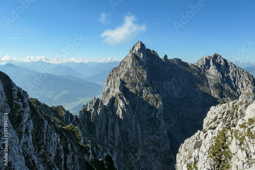 A panoramic view on Alpine slopes in Austria. There are sharp ans steep mountains and high peaks around. The Alpine slopes are almost barren, just moss overgrowing the slopes. Serenity and freedom.