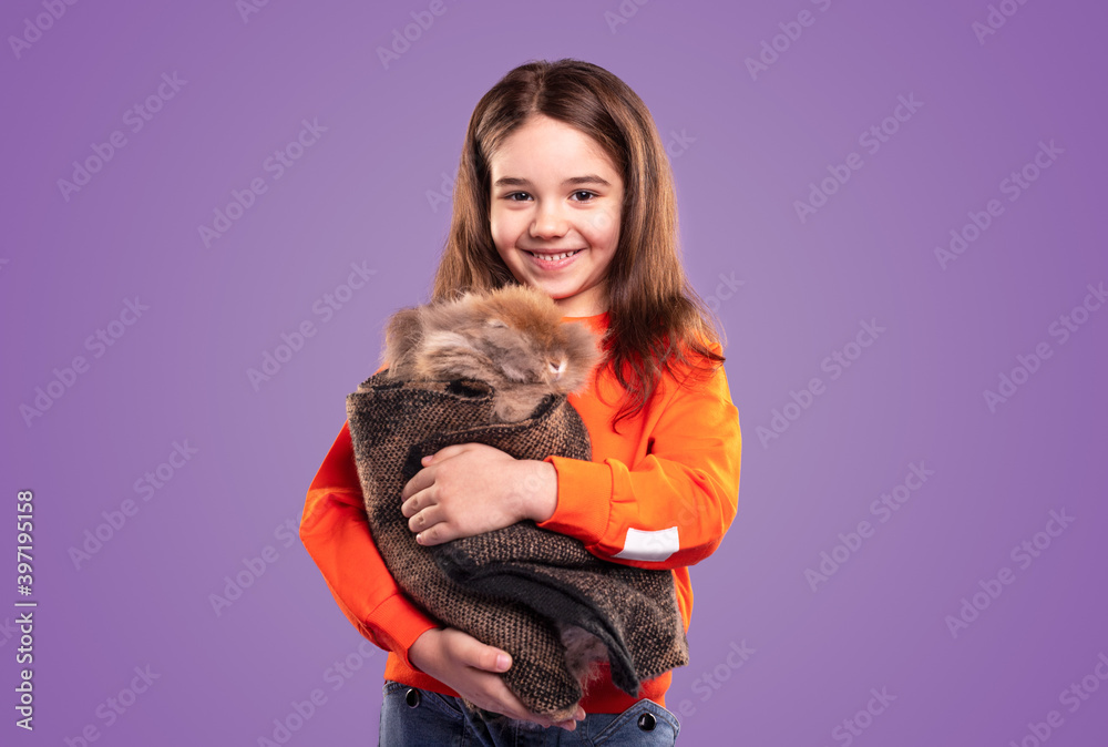 Happy girl hugging rabbit wrapped in cloth Happy girl hugging rabbit wrapped in cloth