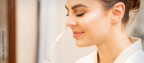 Foto Young woman receiving herbal essential oil flask inhaler in a spa