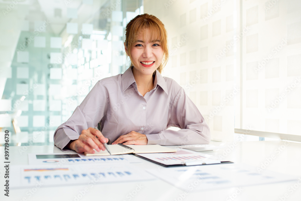 Young Charming asian businesswoman sitting working on laptop in office. Young Charming asian businesswoman sitting working on laptop in office.