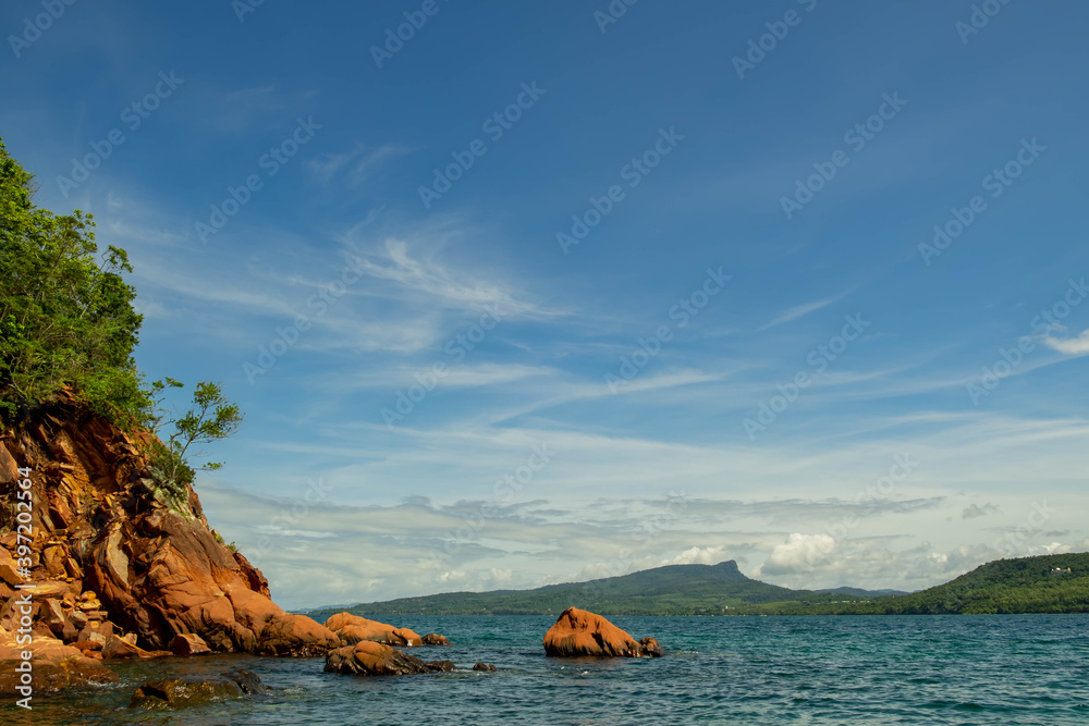 Obraz premium seascape scenic red cliff island with cloudy sky