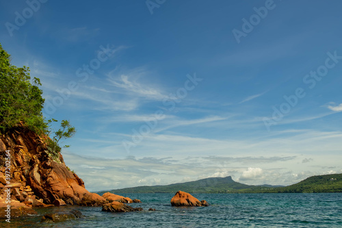 seascape scenic red cliff island with cloudy sky