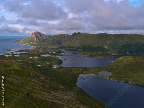 Stunning aerial panorama view of Bleiksvatnet lake, Bleikmorenen nature reserve and fishing village Bleik surrounded by mountains located on northwestern coast of Andøya island, Vesterålen, Norway.
