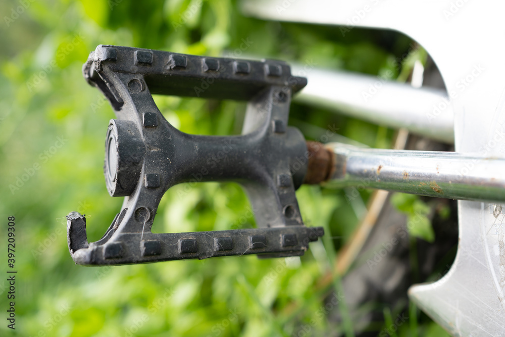 Old broken plastic pedal of an old rusty bicycle