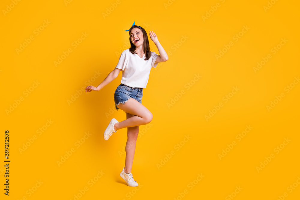Full length body size view of slim pretty cheerful brown-haired girl jumping having fun dancing isolated over bright yellow color background