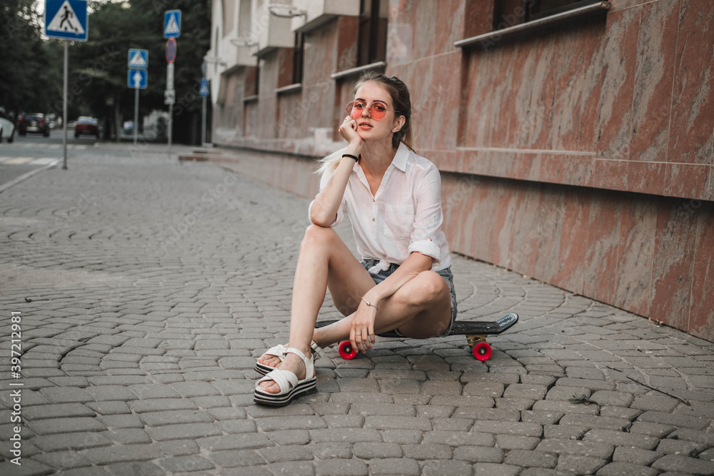 young girl sitting on a skateboard