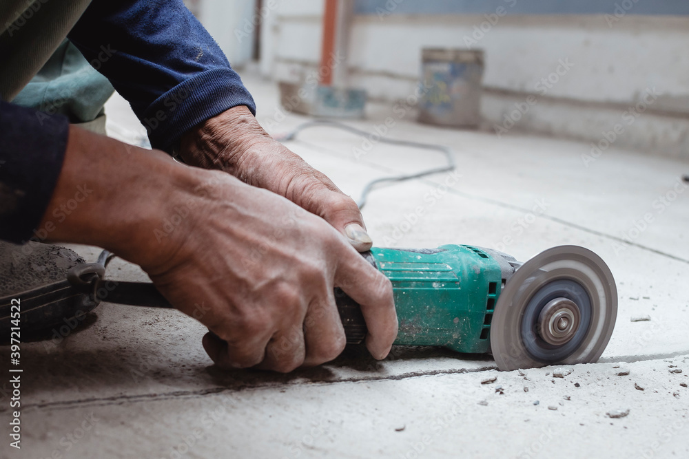 A construction worker uses an angle grinder to cut a line into the concrete  floor. Creating a tile pattern on the surface. Held with bare hands. Stock  Photo | Adobe Stock