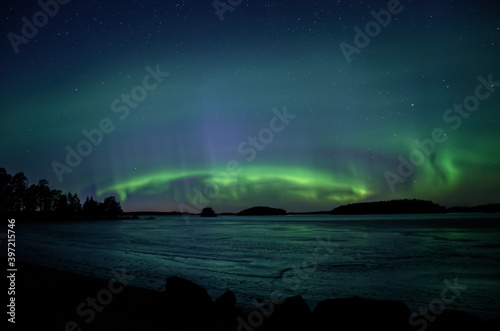 Northern lights dancing over calm lake in Farnebofjarden national park in north of Sweden. © Conny Sjostrom