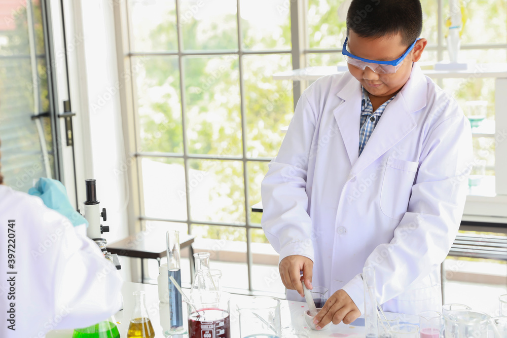 asian boy making science experiments with test tube in class (education and scientist concept) asian boy making science experiments with test tube in class (education and scientist concept)