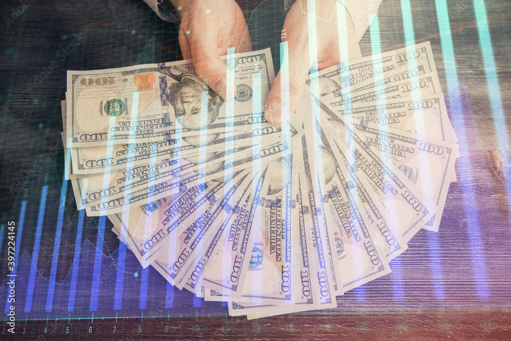 Multi exposure of financial graph drawing hologram and USA dollars bills and man hands. Analysis concept. Multi exposure of financial graph drawing hologram and USA dollars bills and man hands. Analysis concept.