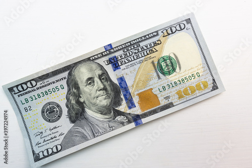 textured background of one hundred dollar bill with a portrait of us President Franklin in orange, red and black colors. blur, defocus.