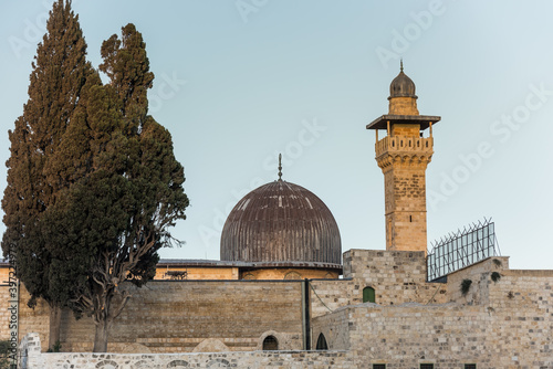 Siliver dome of Al-Aqsa Mosque under sunset in the evening, built on top of the Temple Mount, known as Haram esh-Sharif in Islam and al-Fakhariyya Minaret and wall of old city of Jerusalem, Israel. photo