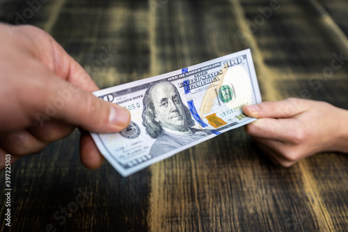 textured background of one hundred dollar bill with a portrait of us President Franklin in orange, red and black colors. blur, defocus.