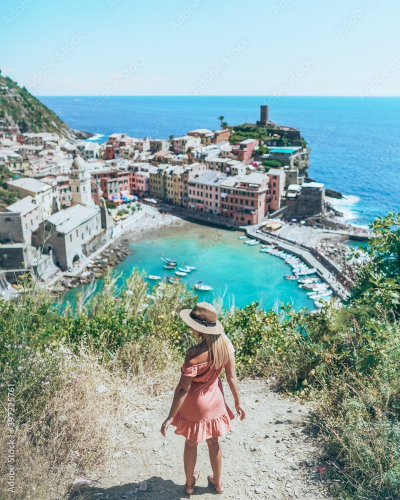 Woman overlooking the cliff and the town of Vernazza, Italy.