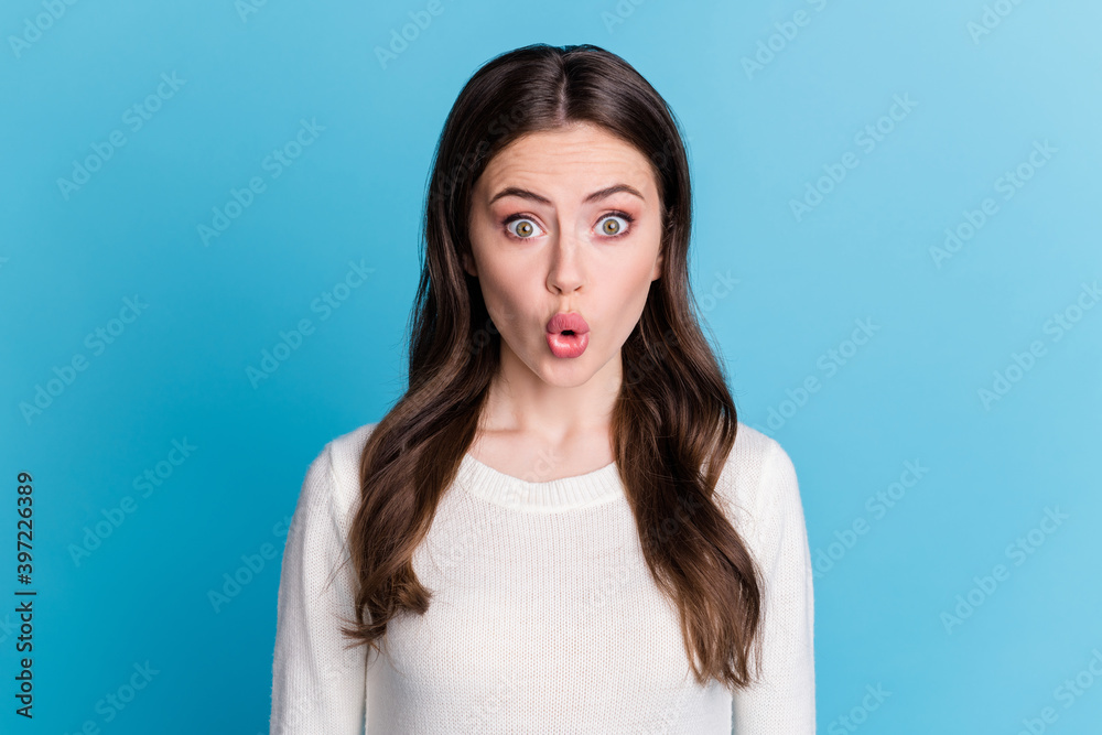 Photo of charming shocked curly woman dressed white pullover big eyes isolated blue color background Photo of charming shocked curly woman dressed white pullover big eyes isolated blue color background