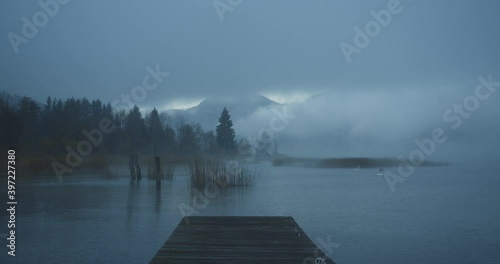 Mist is rising during a foggy break of dawn, while winter is coming over the countryside of lake Mondsee, Austria