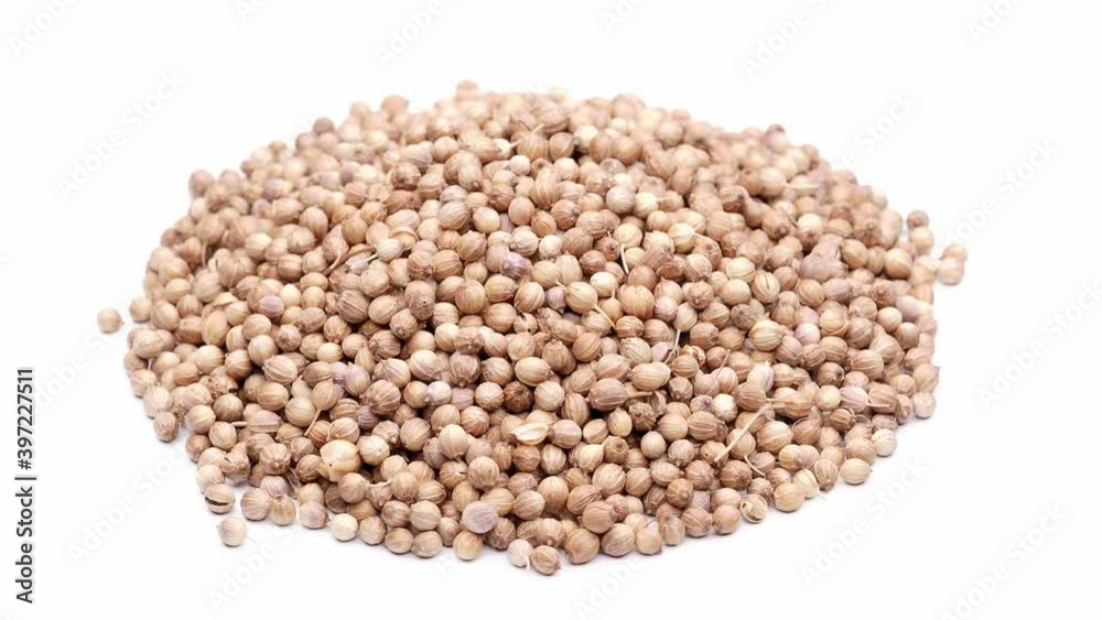 Close-up view of a heap of coriander seeds, isolated on white, seamless loop rotation Close-up view of a heap of coriander seeds, isolated on white, seamless loop rotation