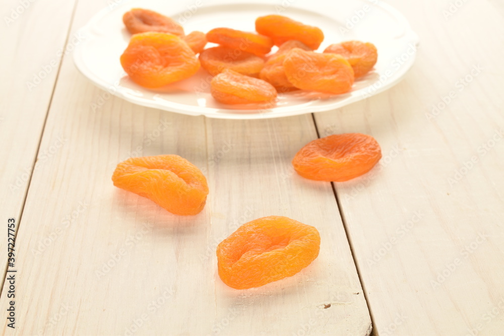 Bright orange natural dried apricots, close-up, on a wooden table. Bright orange natural dried apricots, close-up, on a wooden table.