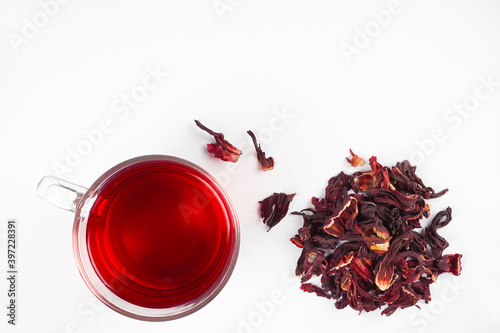Hibiscus tea cup and dried flowers on white background. Vitamin, recipe, beverage concept. Top view, flat lay, copy space