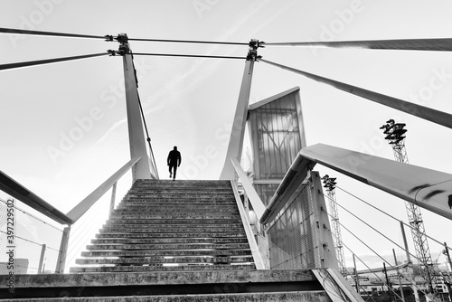Obraz na plátně Silhouette man and bridge over railways track in Paris suburb