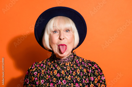 Fotografia Headshot of sly funny crazy granny showing tongue careless childish playful isol
