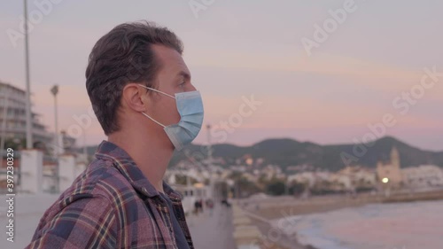 Pandemic, portrait of a young tourist man wearing protective mask walking during lockdown, empty streets. the concept health and safety, N1H1 coronavirus quarantine, virus protection