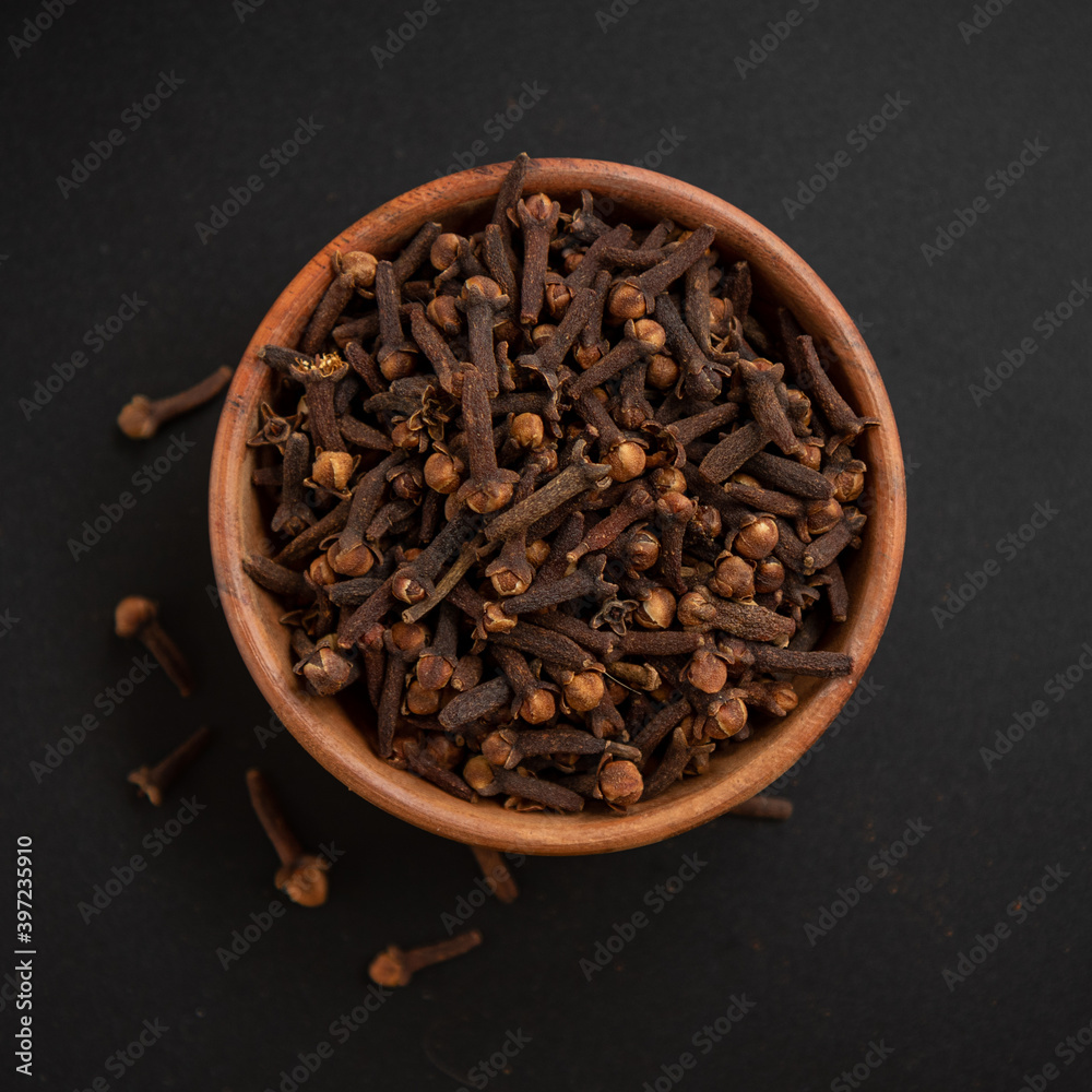 Spice cloves in wooden bowl, food close-up. Spice cloves in wooden bowl, food close-up.