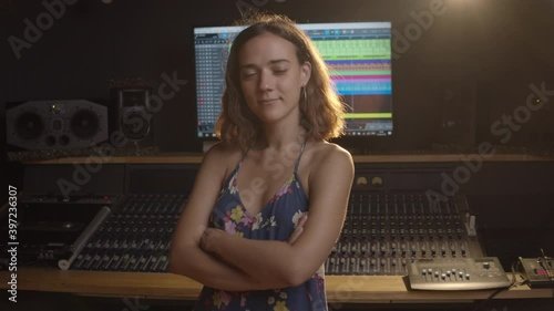 Music production studio. Producer. Portrait of hispanic woman working in the recording studio. An attractive brunette female person in a beautiful dress produces songs. 