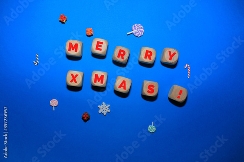 Christmas composition with wooden dice, candies, gifts and blue background