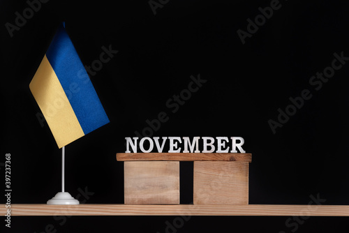 Wooden calendar of November with Ukrainian flag on black background. Dates in Ukraine in November.