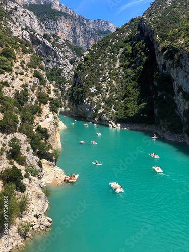 People enjoy the boat ride and swimming on summer holiday in Sainte Croix Lake, green turquoise artificial lake or Les Gorges du Verdon, Provence. Largest green canyon in France. Selective focus