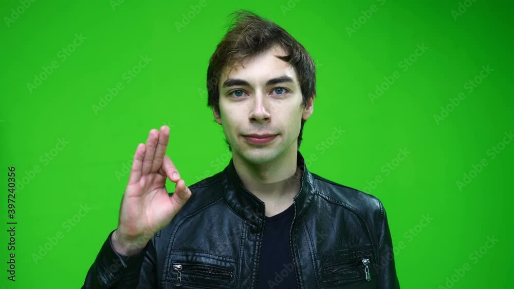 White man in leather jacket showing approval or ok sign on green screen background. White man in leather jacket showing approval or ok sign on green screen background.