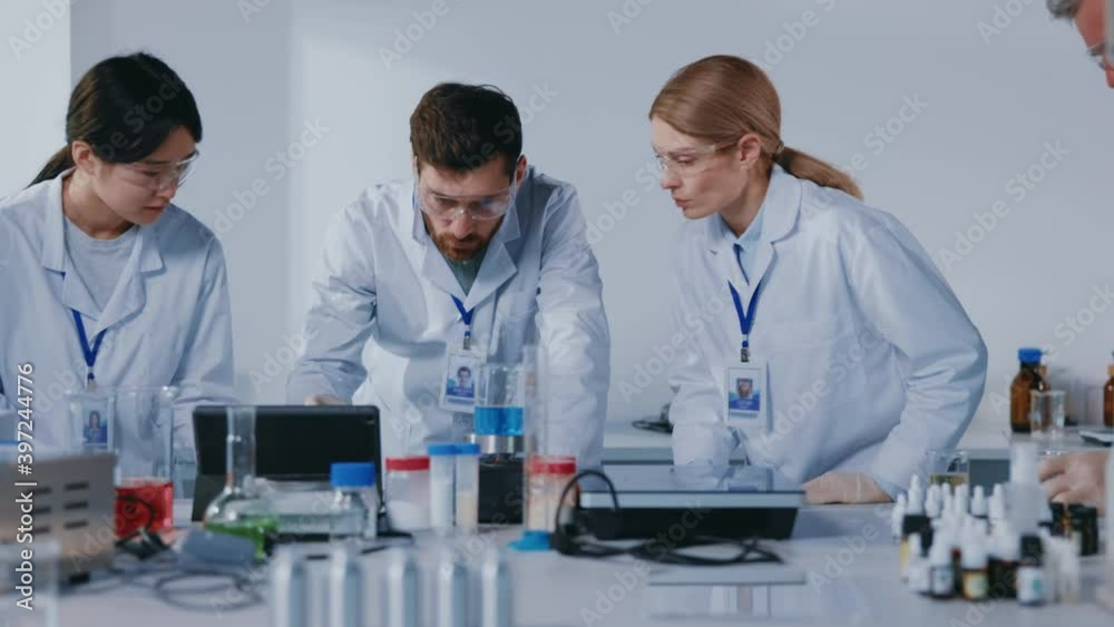 In modern equipped laboratory teamwork of scientists working biological researches under microscope. Virus evolution using high tech. Microbiology medical staff biotechnology. Slow motion In modern equipped laboratory teamwork of scientists working biological researches under microscope. Virus evolution using high tech. Microbiology medical staff biotechnology. Slow motion