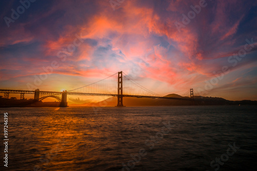 Photography Gorgeous orange sunset with pink clouds over the Golden Gate in San Francisco, California