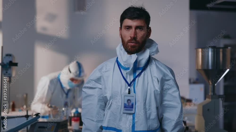 Portrait young man scientist removes protective suite look at camera in laboratory. Epidemic chemical virus pandemic uniform quarantine. Slow motion Portrait young man scientist removes protective suite look at camera in laboratory. Epidemic chemical virus pandemic uniform quarantine. Slow motion