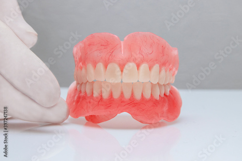False teeth prosthesis. Doctor Dentist. A dental technician holds a false jaw in his hand.