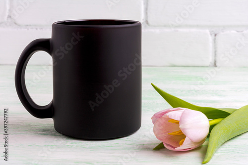 Black coffee mug mockup with gentle pink tulip