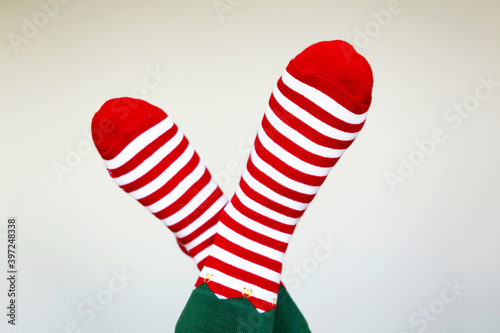 Female feet in Christmas socks on white background. Concept of New Year celebration, elf costume