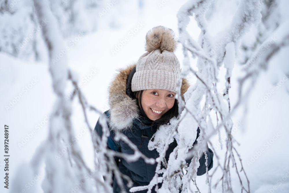 Fototapeta premium Portrait of the young Asian woman in winter forest