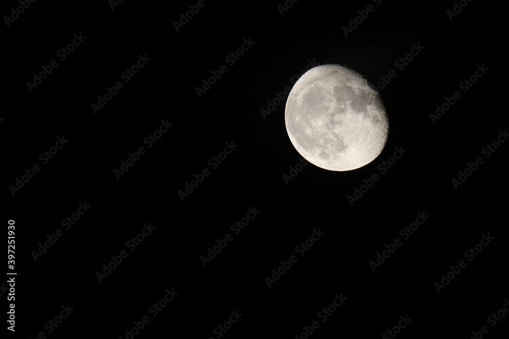 Low angle view of Moon against the clear sky at night. Close photography of the Moon with a view of craters and landscape Low angle view of Moon against the clear sky at night. Close photography of the Moon with a view of craters and landscape