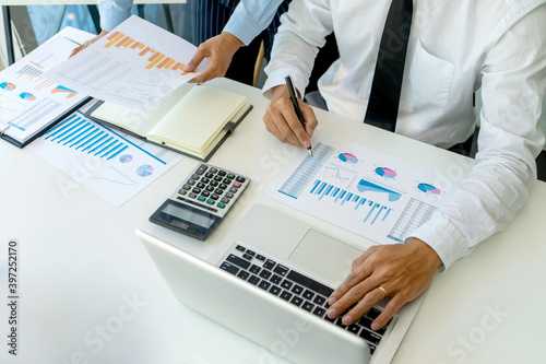 Businessman pointing at graphs paper of business in a graph analysis