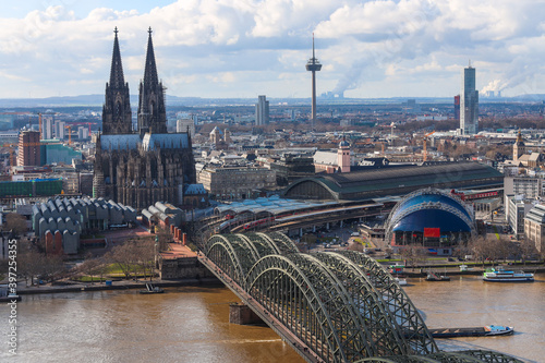 Panoramic cityscape over Rhine River of Cologne city (Cologne Cathedral, Hohenzollern Bridge and Colonius) Cloudy blue and White Sky at Background. photo