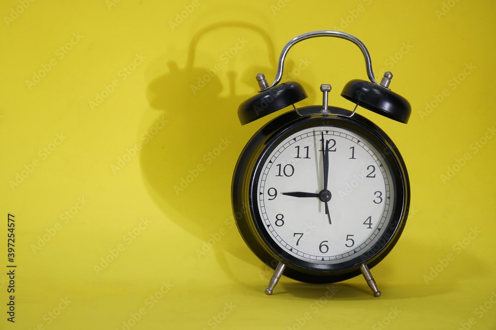Black alarm clock on yellow background. Black alarm clock on yellow background.