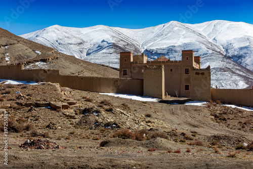 View of castle in Imilchil in front of snowy mountains, Morocco