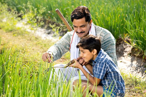 Happy farmer with son in agricultural field