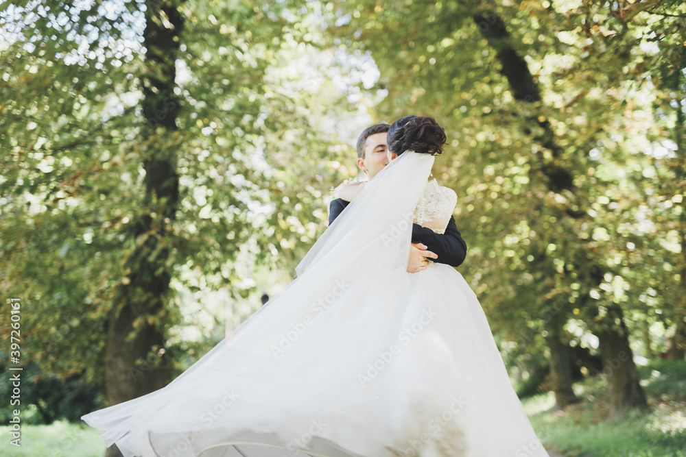 Happy wedding couple charming groom and perfect bride posing in park Happy wedding couple charming groom and perfect bride posing in park