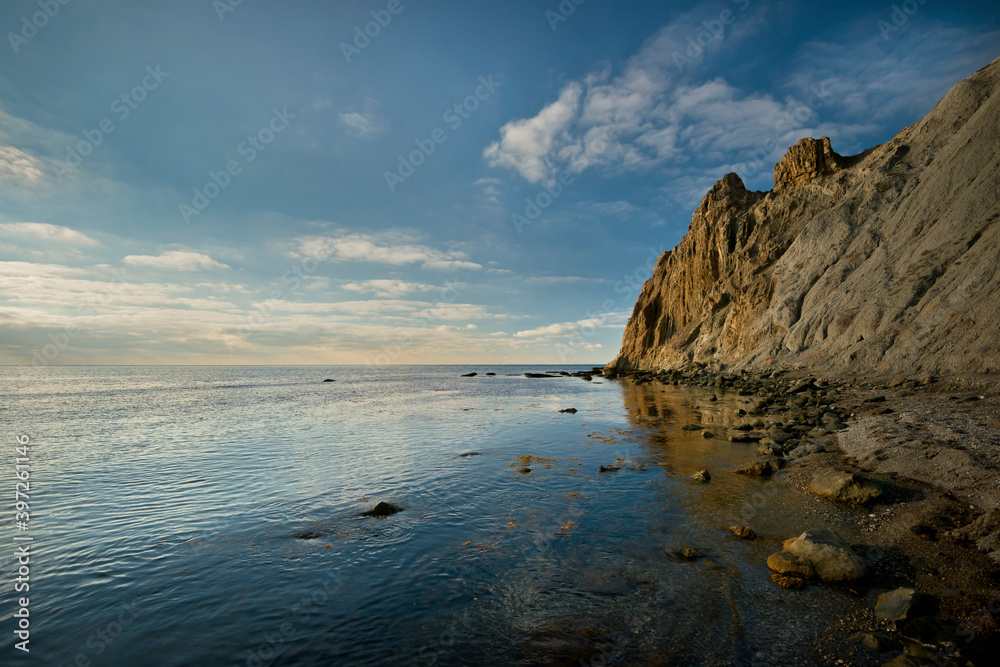 Landscape with calm sea and rock.