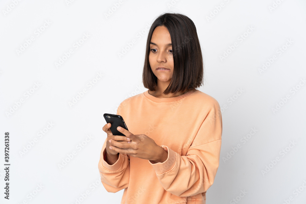 Young latin woman isolated on white background sending a message or email with the mobile Young latin woman isolated on white background sending a message or email with the mobile