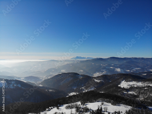 Radziejowa Range and High Tatras Mountains in sunny winter day. View from Jaworzyna Kokuszczanska, Beskid Sadecki, Poland.